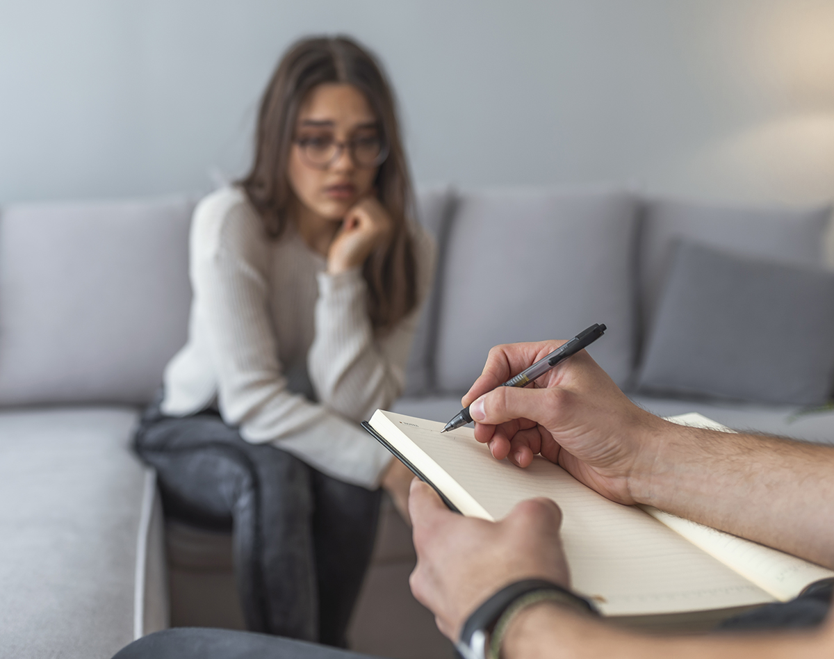 Psychologist listening to woman in trouble during therapy session