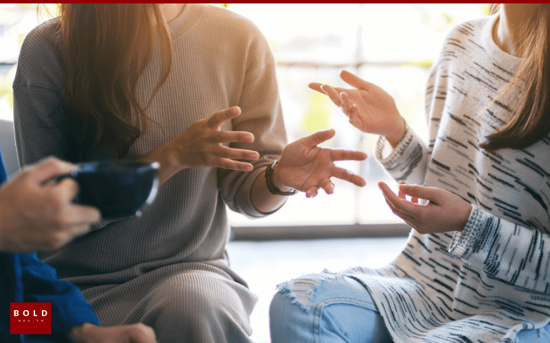 Group of diverse clinicians in a support group session discussing mental health in an office setting.