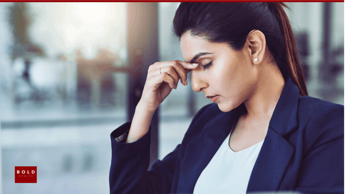 Woman with hand on forehead showing stress, mental health, burnout, depression, emotional health.