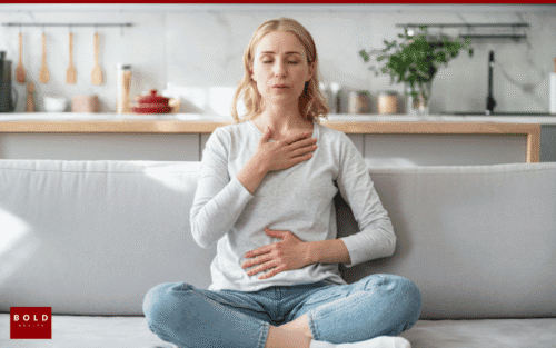 Woman meditating on a sofa, practicing breathing exercises for stress relief and relaxation at home.