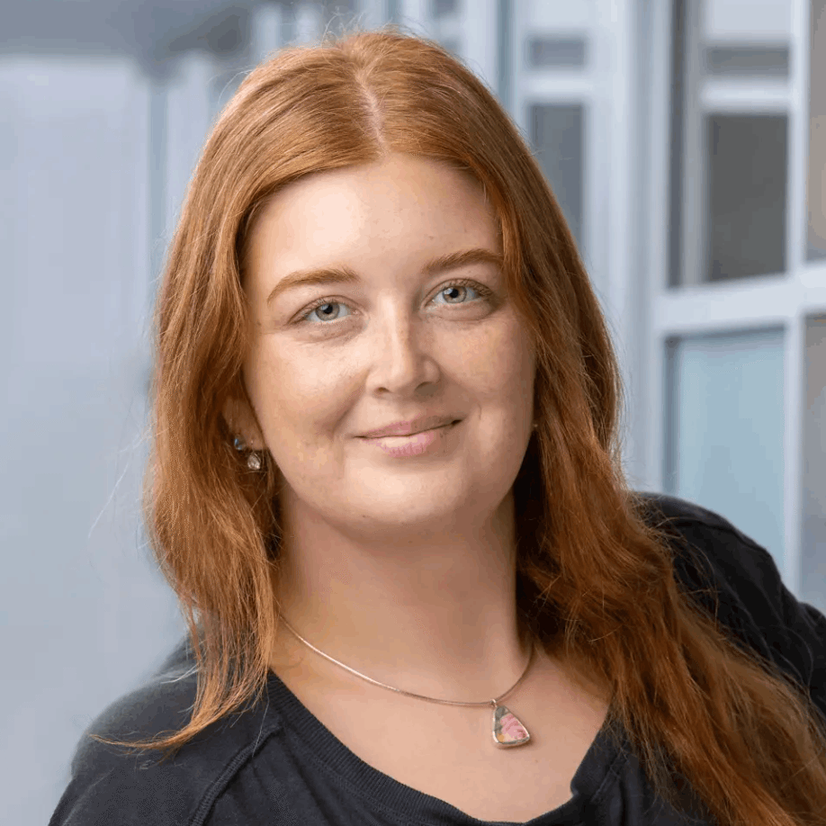 Red-haired woman smiling in professional setting, representing Bold Health team member.